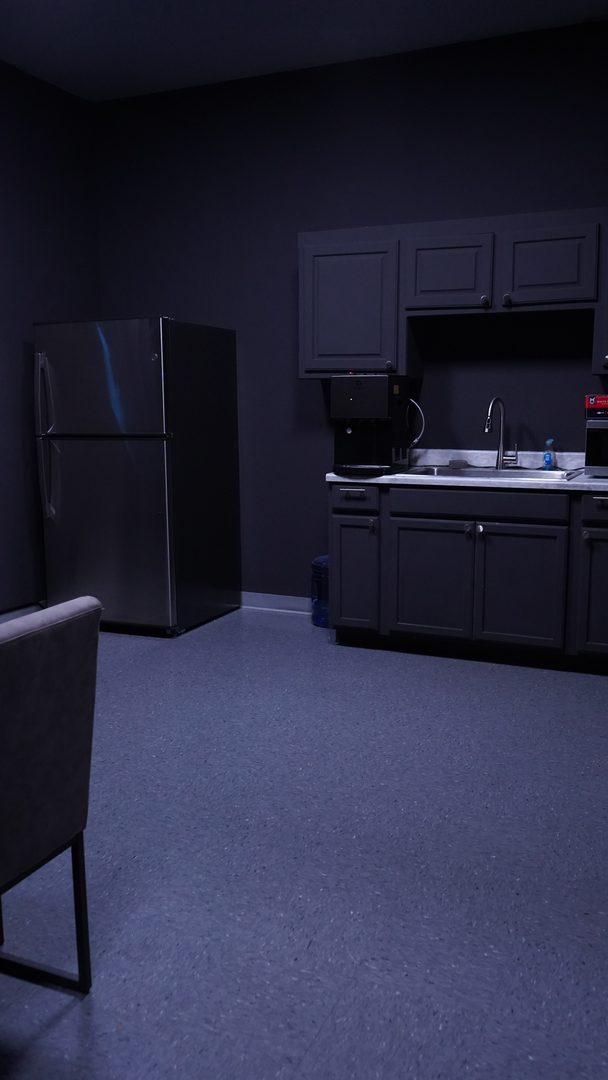 Kitchen with a stainless steel refrigerator, sink and dark grey cabinets