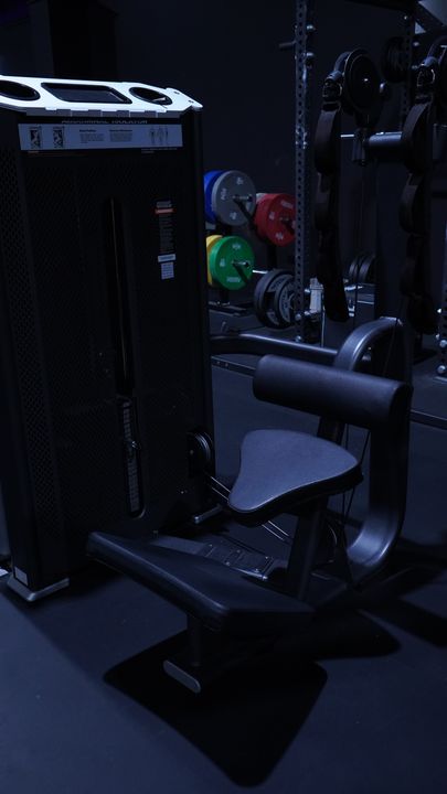Selectorized machine with black seat beside colored bumper plates