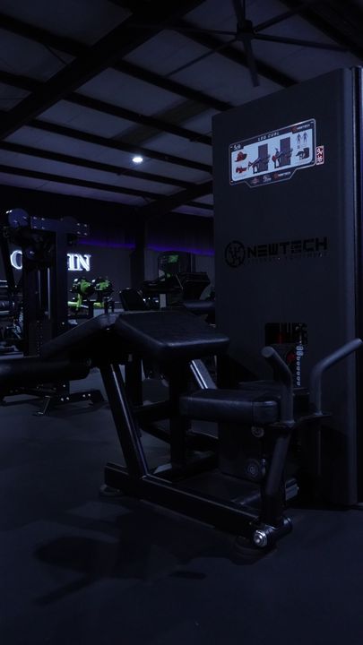 Newtech leg machine with weight stack and the Origin sign behind
