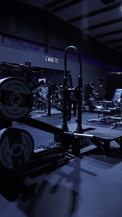 Plate loaded machine with Technogym plates below the clock