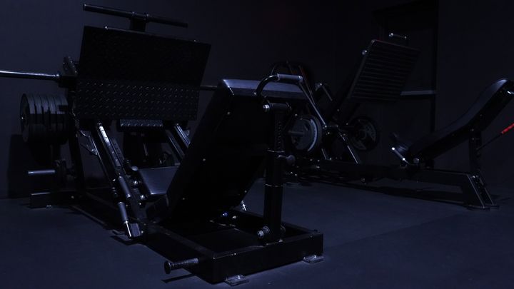 Plate loaded hack squat with loaded plates on the floor